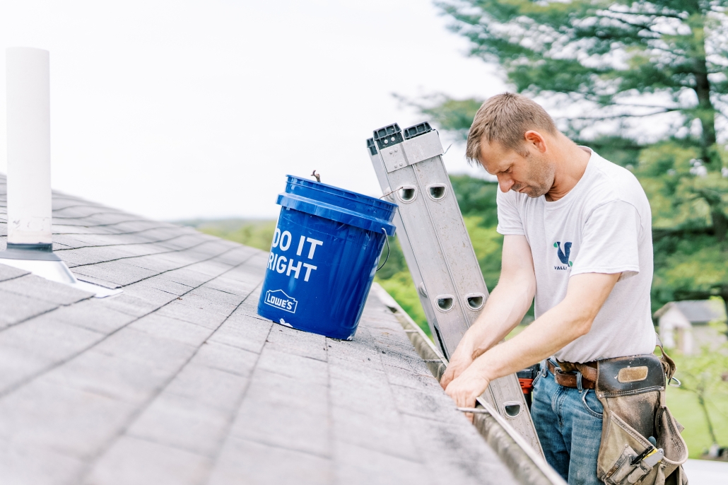 Valley Roofing & Exteriors worker cleaning gutters.