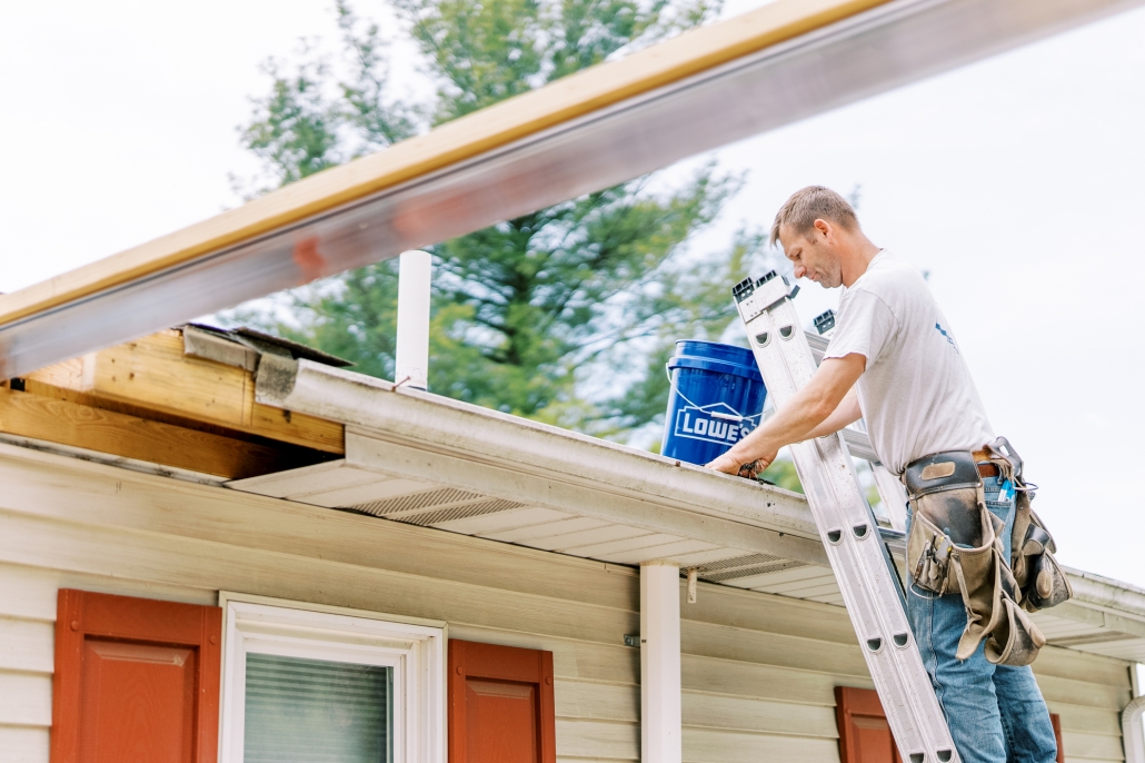 Valley Roofing team member cleaning house gutters.